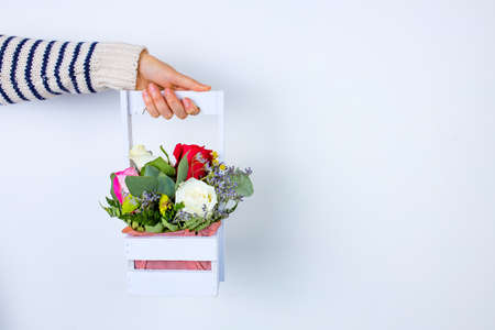 hand holding flowers in wooden basket, holiday giftの写真素材