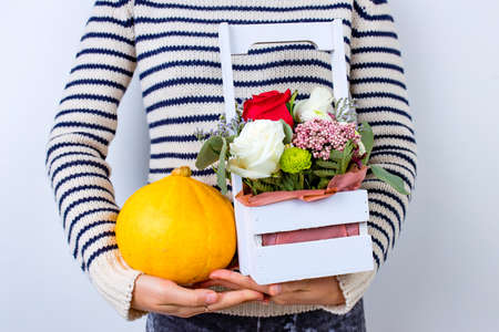 hand holding flowers in wooden basket, holiday giftの写真素材