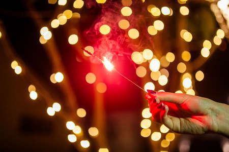 hand with sparklers on a beautiful backgroundの写真素材