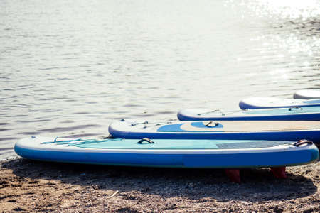 Young attractive couple on stand up paddle board in the russian lake