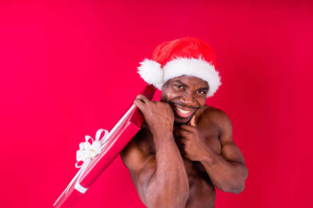 nude latino hispanic mixrd race man holding gift in studio red background