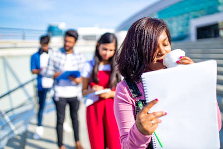 indian students keeping distance and do home work outdoorsの写真素材