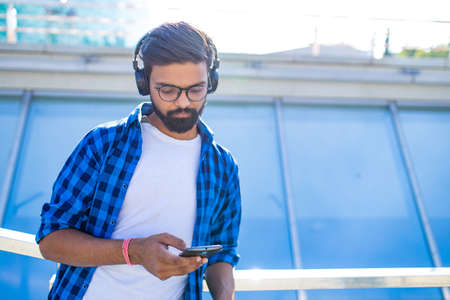 handsome bearded brunette arabian man listen musics outdoor street