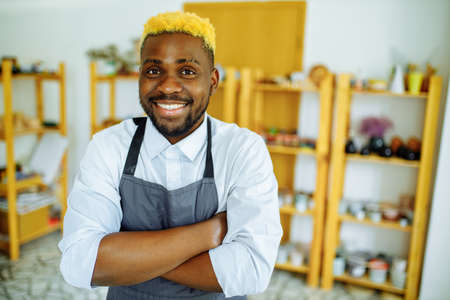 mixed race man making a vase in pottery studioの写真素材