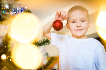 Child decorating Christmas tree at homeの写真素材