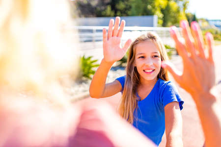 mom and daughter give each other high five on the streetの写真素材