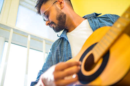 Giving guitar online lesson.Indian man is playing the guitarの写真素材