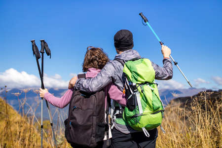 Hikers newwedding with backpacks relaxing on top of a mountain in honeymoonの写真素材