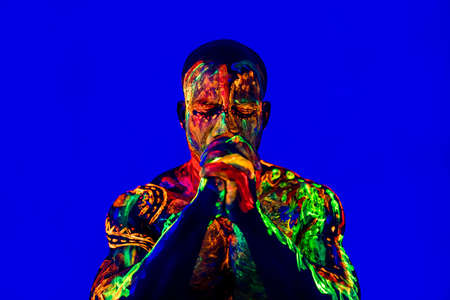 afro american man with UV body art posing in studioの写真素材
