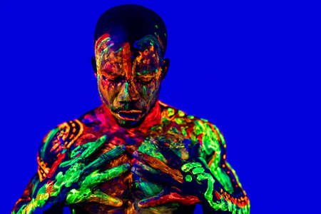 afro american man with UV body art posing in studioの写真素材