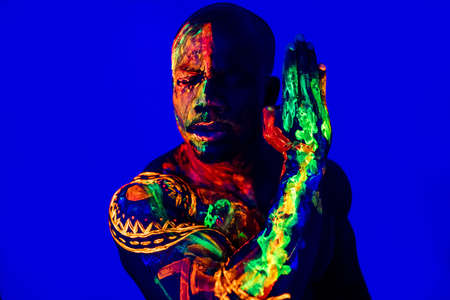 afro american man with UV body art posing in studio