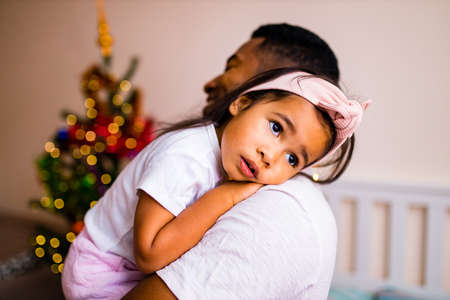 happy mixed race dad and beautiful child in the merry x-mas morning in bedroom