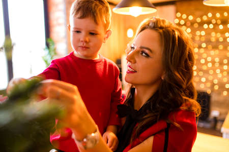 beautiful mama and kid decorated a tree with ball in living room happiness eve holidayの写真素材