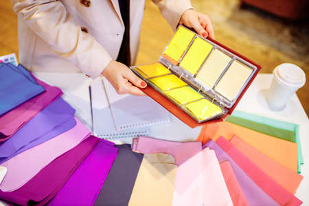 Young stylist helping customer to choose clothes colors