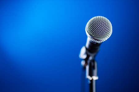 Microphone on stage against a background blue recording studio