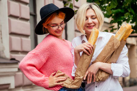 happy women using social network app meeting website outdoors in Europe French streetsの写真素材