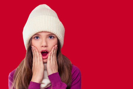 Beautiful little girl in the winter warm hat and scarf and medical mask stylish fashion child look in winter new year timeの写真素材