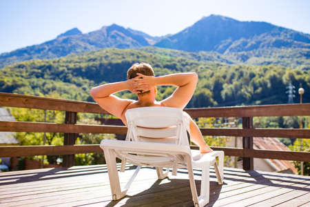 man in the pool looking at mountain landscape.Enjoying beautiful mountainsの写真素材