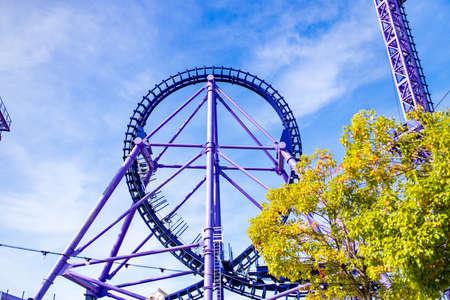 summer blurred photo of Rollercoaster against blue skyの写真素材