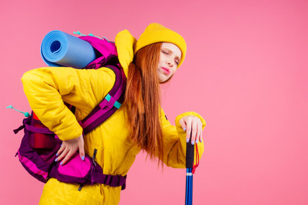 Happy woman ready for travel to mountains in new yellow jacket