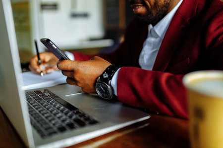african american man getting online education and drinks coffee to go frop paper eco cupの写真素材