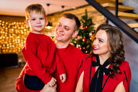 Young family staying at home on Christmas holidays and having quarantine party in living roomの写真素材