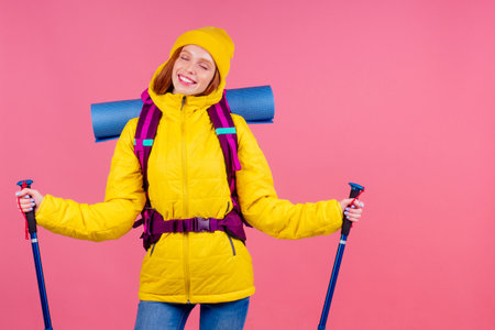 Happy woman ready for travel to mountains in new yellow jacketの写真素材
