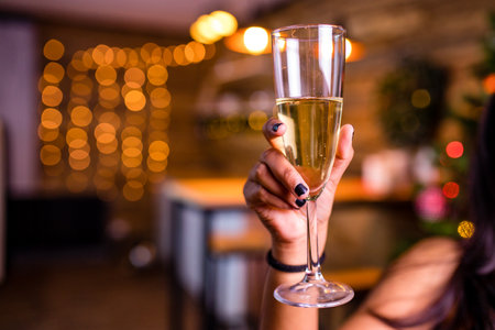 indian woman drinking alcohol at studio shot spruce Christmas tree lights garland backgroundの写真素材