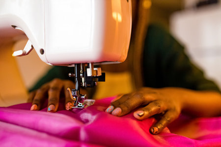afro american stylist sewing all night long and feeking badの写真素材