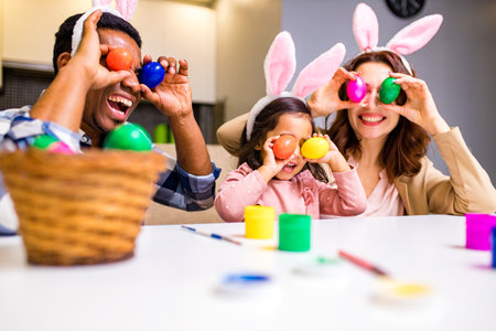 mixed race family coloring Easter eggs in living room