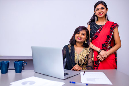 Two indian colleages discussing ideas using a tablet computer at the office
