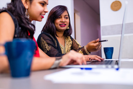 two beautiful women in tradition sari working at office or cafeの写真素材