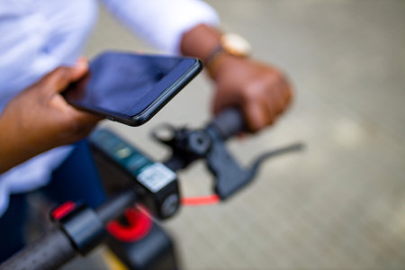 afro american woman activate and prepay a rental e-scooter or an e-bicycle on the street