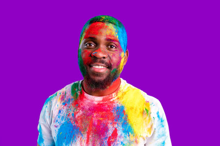 latin brazilian male in white cotton t-shirt with colorful paint of face laughing studio