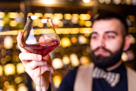 arabian man sommelier appreciating drink in lux hotelの写真素材