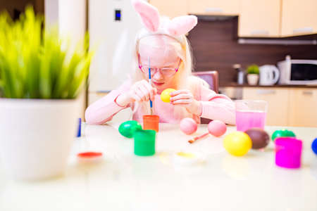 Cute little child blond girl wearing bunny ears on Easter dayの写真素材