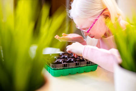 blonde albino young little farmer planting at home