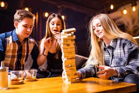 Young people have fun playing board games at a table .の写真素材