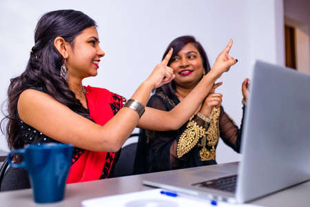 Two indian colleages discussing ideas using a tablet computer at the office