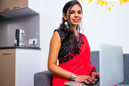 business women in sari laptop working in living room at homeの写真素材