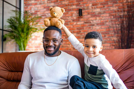 afro american baby giving to dad a Valentines Day picture in living roomの写真素材
