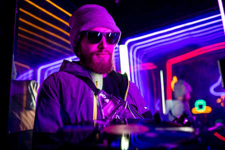 robotics dj man with metal hand nostalgia about past time in neon studio feeling loneliness hold disc for vinyl recordの写真素材