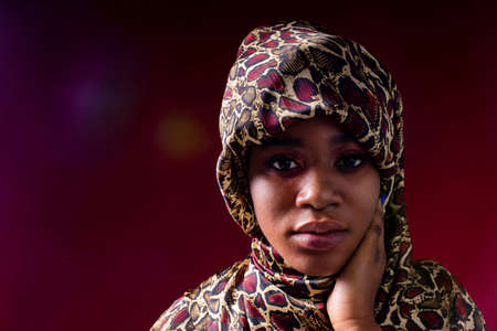 zanzibar woman with headwear in red studio wall backgroundの写真素材