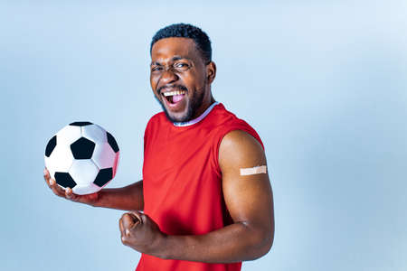 afro american sportsman showing his arm after receiving a vaccine in studioの写真素材