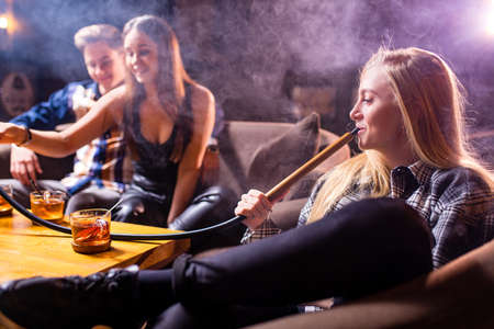 Friends party in hookah lounge smoking shisha night timeの写真素材