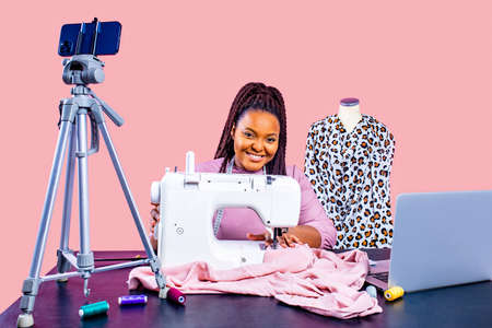 Young seamstress shooting with a phone camera for a blog