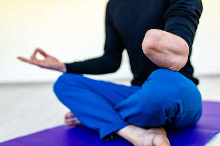 amputees handisport young man doing yoga exercises indoors at homeの写真素材