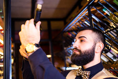 happy successful male winemaker is tasting a flavor and checking red wine qualityの写真素材