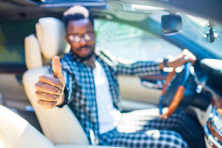 Handsome bearded man sitting relaxed in his newly bought car outdoors