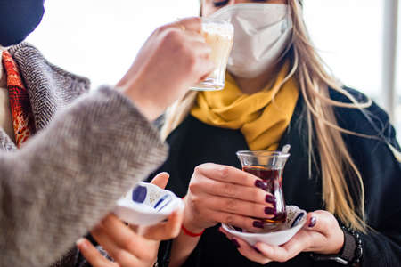 woman drinking Turkish tea in the front, bosphorus bay in the backgroundの写真素材